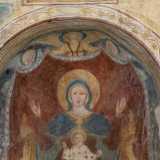 Ha sul grembo Ges� benedicente con il globo sulla mano sinistra. In alto tre angeli reggono il drappo color rubino che fa da sfondo all�opera